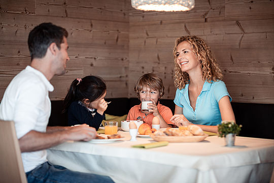 Familien sitzt gemeinsam am Tisch und essen