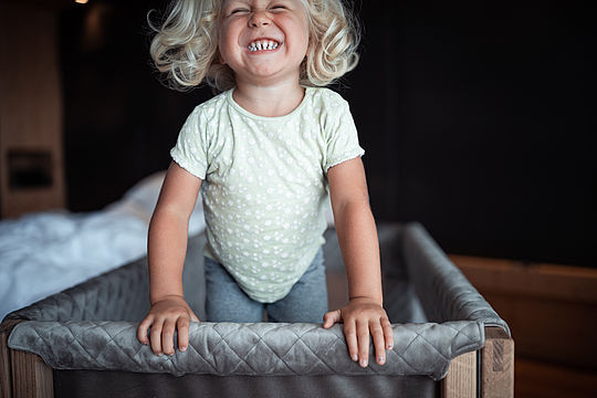 Child bouncing in the baby cot