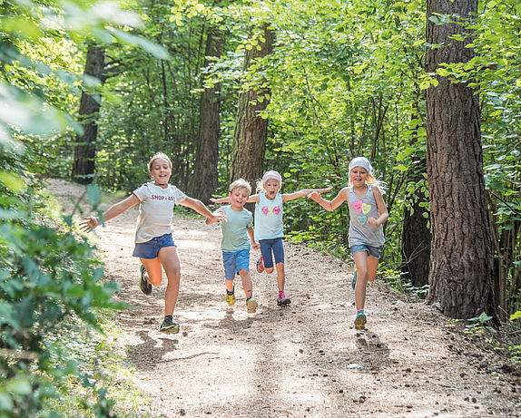 Bambini che corrono nella foresta
